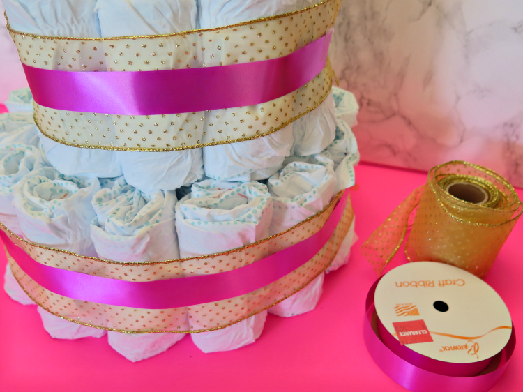 The diaper cake is a classic staple at any baby shower. Step it up a notch with this modern sophisticated twist on the classic for your next shower!